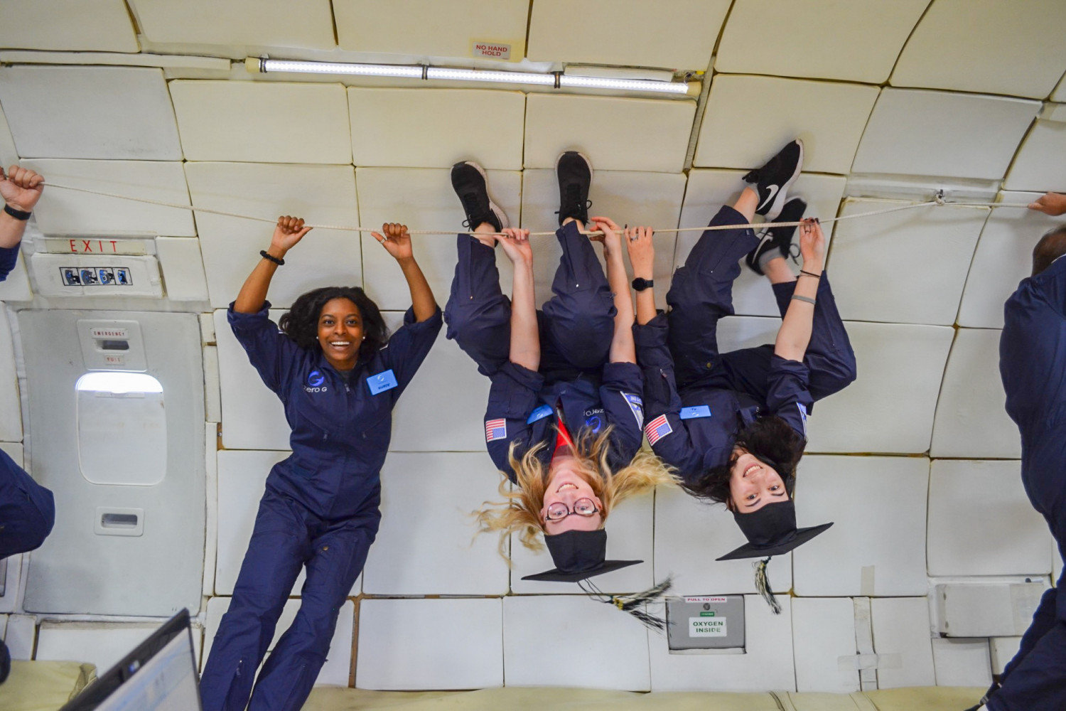 Students on board NASA's zero gravity aircraft take a break from conducting research to celebrate their graduation.