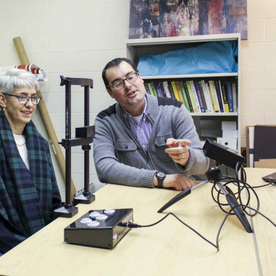 Profs. Leslie Cameron and Anthony Barnhart examine the technology helping them with their eye tracking experiment.