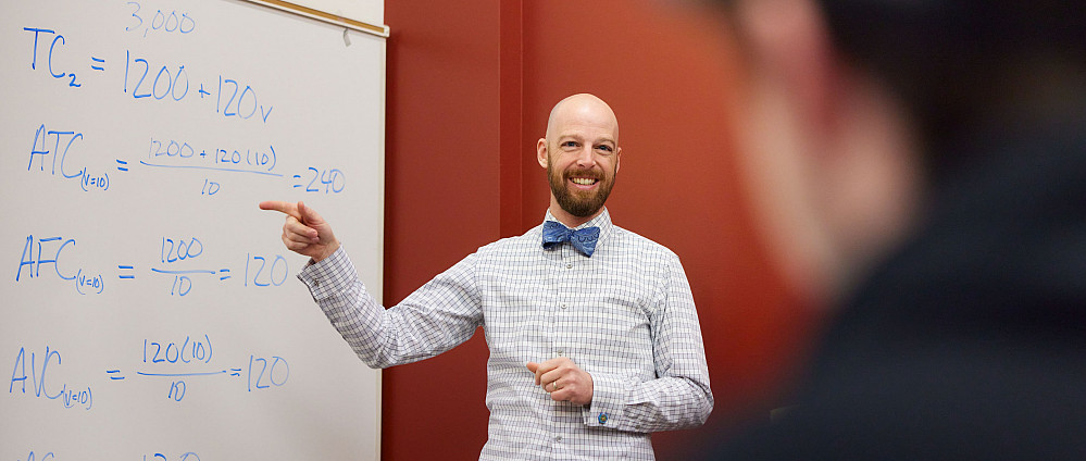 Professor Erik Johnson teaching in front of a whiteboard.