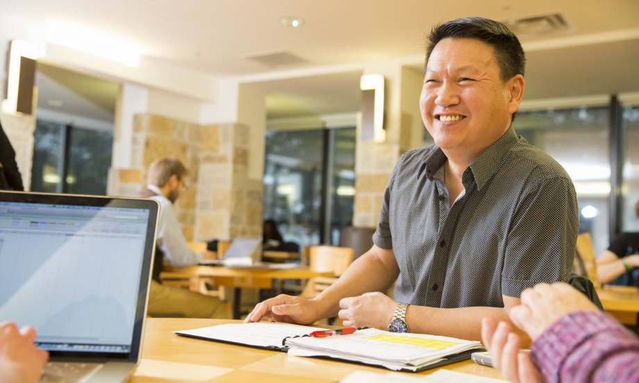 A graduate student studies with fellow students in Hedberg Library.