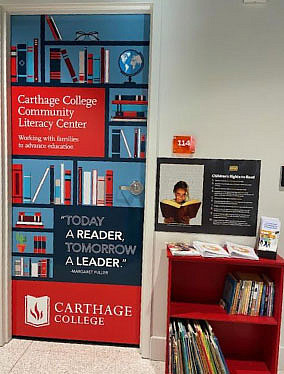 A door with the Carthage College Community Literacy Center logo and a small book shelf with books.