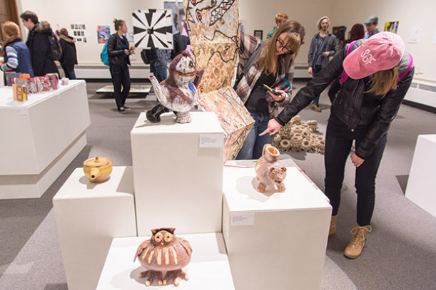 Patrons view artwork in an exhibit in the H. F. Johnson Gallery of Arts.