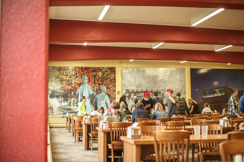 Students sit down to eat a meal at The Caf.