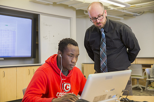 Prof. Daniel Steiner assists a student during class.