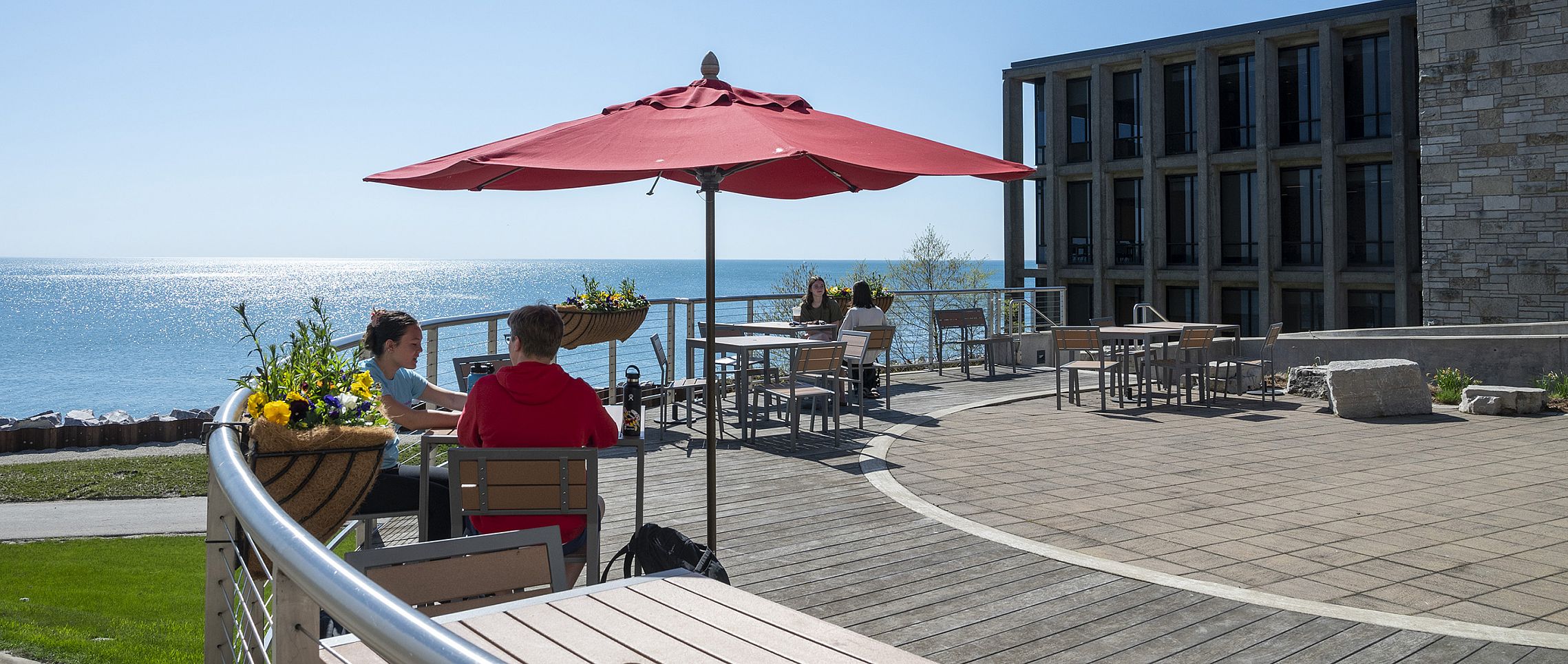 Students enjoy the nice weather and Lake Michigan view from the Straz patio.