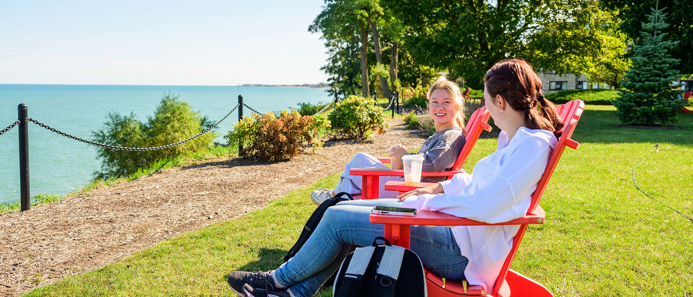Students sitting on red chair facing Lake Michigan.
