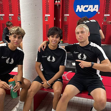 Three men's soccer players in the locker room.