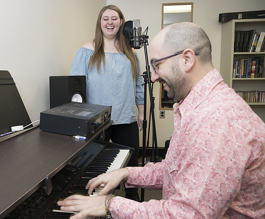 A Master of Music student works with a faculty member.