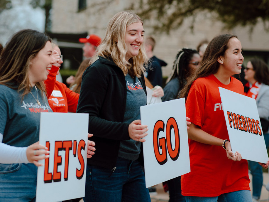 ?Let's Go, Firebirds!? Students walk in the Homecoming Parade.